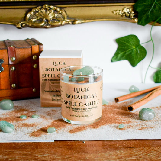 Luck botanical spell candle with packaging and decorative elements on a wooden surface