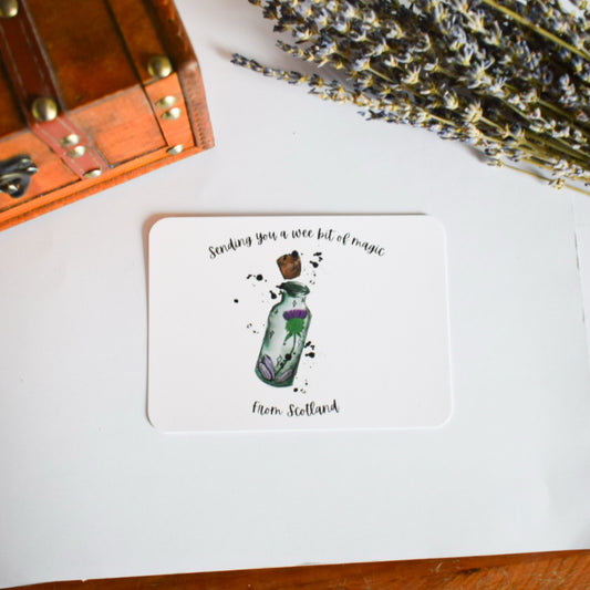 Card with a bottle illustration and text on a white surface with lavender.