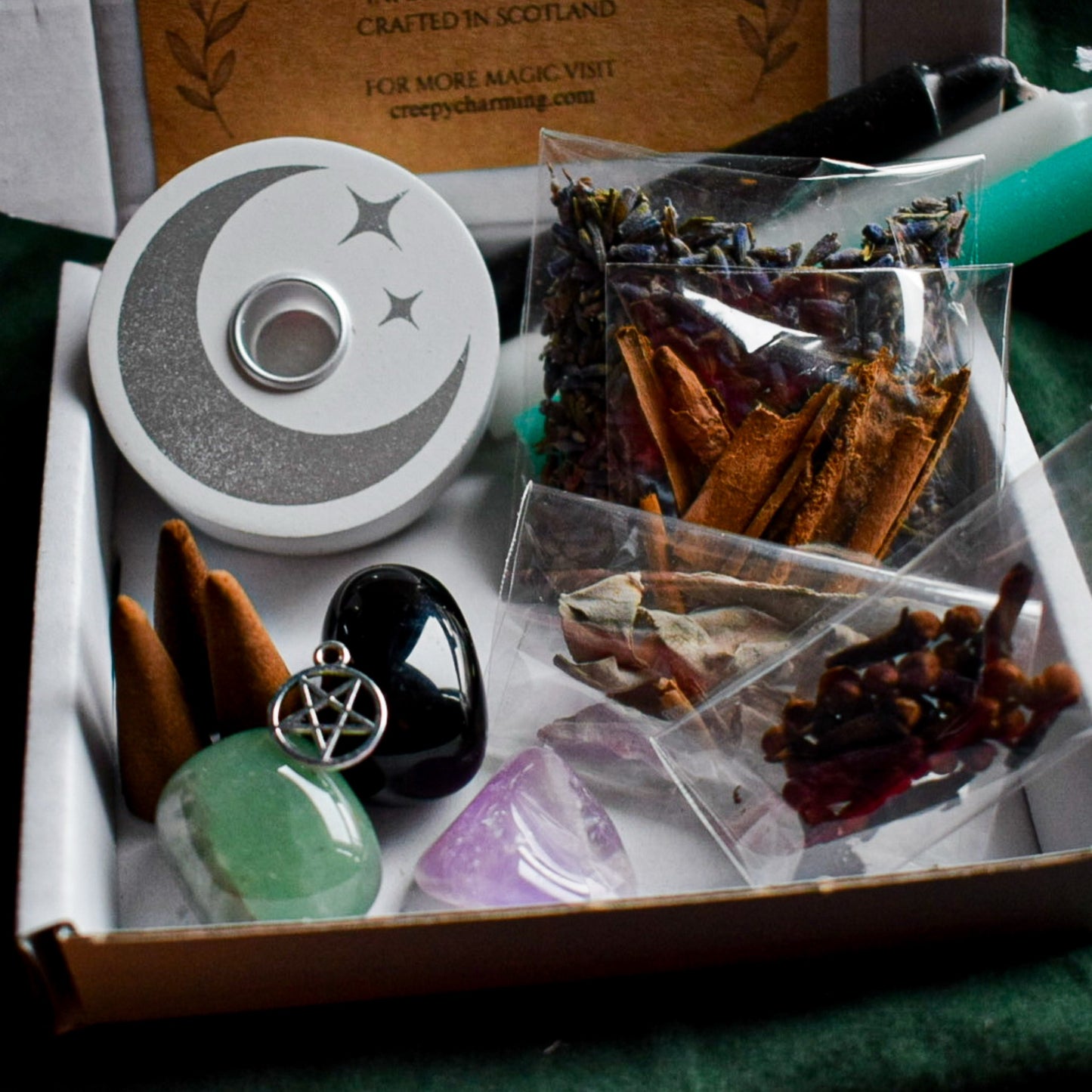 Witchcraft supplies including a pentacle pendant, crystal, and pouches in a box.